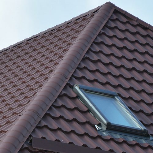 New roofing construction with attic skylights, rain gutter system, roof windows and roof protection from snow board, snow guard exterior. Modern House Construction. Hip and Valley roofing types.